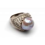 Platina bolle ringgezet met een grillige roze parel. Kop gezet met kleine diamanten bruto 12,0 gr.