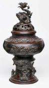 Räuchergefäß, China wohl um 1900. Bronze, dunkel patiniert. Gedrückte Kugel auf hohem rd. Stand,