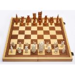 Schachspiel, Erbach um 1980. Elfenbein, vollrd. geschnitzt, partiell gefärbt. Versch. Figuren in