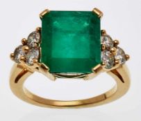 Smaragd-Ring18 kt GG besetzt mit einem Smaragd v. ca. 6 ct im Treppenschliff, flankiert von zwei