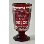 Andenkenglas, Böhmen, Mitte 19. Jh. Fußbecher, farbloses Glas, parteill rot lasiert, auf der
