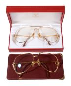 Cartier, two pairs of gilt finish spectacles or glasses, one with a ribbed bridge the other with