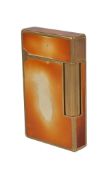 S. T. Dupont, a rectangular gas lighter, gold plated with an amber/ white lacquer finish, in a