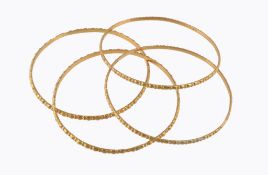 Four gold coloured bangles, with textured decoration, stamped 22c, 38.7g