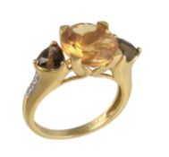 An 18 carat gold citrine, smokey quartz and diamond ring, the central circular cut citrine claw