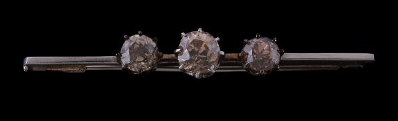 A diamond three stone bar brooch, the central old brilliant cut diamond, estimated to weigh 0.70