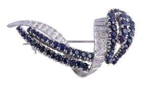 A sapphire and diamond crossover brooch, the curved abstract brooch set with circular cut