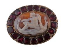 A 19th century shell cameo and garnet brooch, circa 1840, the oval shell carved with a seated