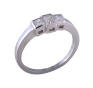 A three stone diamond ring, the central step cut diamond with canted corners between two princess
