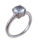 An aquamarine and diamond ring, the circular cut aquamarine claw set within an eight cut diamond
