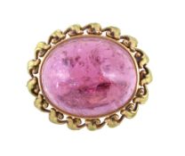 A late Victorian pink tourmaline brooch , circa 1900, the oval cabochon tourmaline within a green