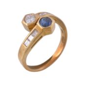 A sapphire and diamond crossover ring, set with an oval cut sapphire and an oval cut diamond,