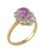 A pink sapphire and diamond cluster ring, the oval cut pink sapphire claw set within a surround of