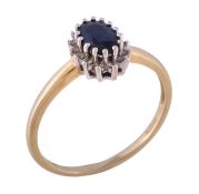 A sapphire and diamond ring, the oval cut sapphire claw set within a surround of eight cut