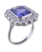 A tanzanite and diamond cluster ring, the step cut tanzanite with canted corners estimated to weigh