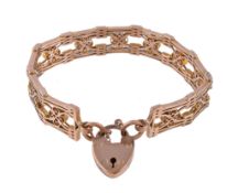 A late Victorian gold gate link bracelet, circa 1900, the panels centred with a scrolled quatrefoil