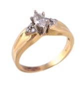 A diamond ring, the marquise cut diamond between brilliant cut diamond set shoulders, stamped 18K,