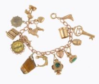 A gold coloured charm bracelet, the curb link bracelet stamped 9 375, suspending various charms,