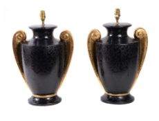 A pair of black and gold glazed ceramic urn table lamps, modern, each with twin scrolled handles,