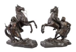 A pair of French patinated bronze models of rearing horses with attendants, loosely in the manner