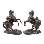 A pair of French patinated bronze models of rearing horses with attendants, loosely in the manner