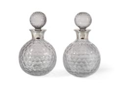 Asprey, a pair of cut glass golf ball style decanters and stoppers with silver mounts by Asprey,