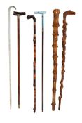 Ω A small quantity of assorted walking sticks, comprising a late Victorian twisted glass frigger