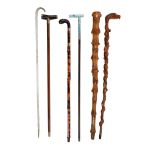 Ω A small quantity of assorted walking sticks, comprising a late Victorian twisted glass frigger