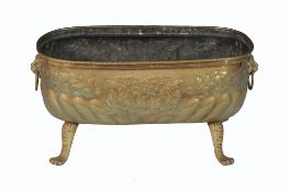 A brass floor standing jardiniere , of shaped elongated oval form, embossed foliate decoration, on