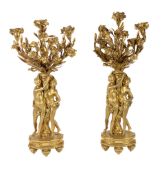 A pair of French gilt bronze figural three light candelabra, late 19th century, the sockets cast as