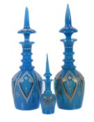 Two similar turquoise, enamelled and gilt glass bottles and spire stoppers, Bohemian for the Near