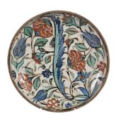 An Iznik dish , late 16th or early 17tn century, of shallow rounded form with everted rim on a