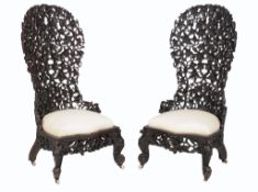 A pair of Burmese carved wooden chairs , each with balloon shaped back carved and pierced