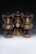 A French porcelain Sevres-style blue-ground gilt-metal mounted two-handled clock garniture, third