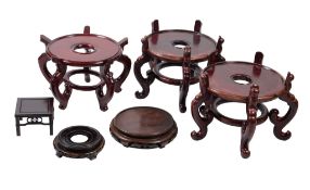 Six various Chinese wood stands, 20th century, comprising a large circular pair supported on five