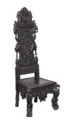 A carved hardwood high back chair , 20th century, South East Asian, the back carved with elephants,
