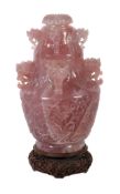A large Chinese rose quartz vase and cover, the tapering body carved with scrolling foliage, the
