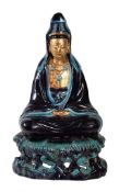 A large Chinese glazed pottery figure of Guanyin, Qing Dynasty, glazed in aubergine and turquoise