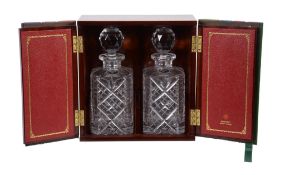 A mahogany decanter case, two faux leather book doors, opening to two cut glass decanters, 28cm