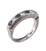 An emerald and diamond ring, set with alternating circular cut emeralds and brilliant cut diamonds,