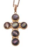 An early 20th century abalone shell cross pendant, circa 1900, the cross set with circular abalone