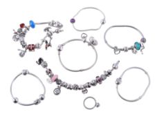 A collection of Pandora silver coloured charm bracelets, suspending various charms, some signed