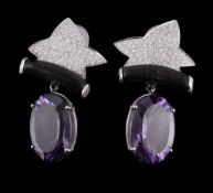 Ω A pair of amethyst, ebony and diamond earrings, the oval fancy cut amethyst claw set below an