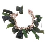 A 9 carat gold curb link charm bracelet, suspending various carved nephrite charms, including a