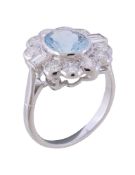 An aquamarine and diamond cluster ring, the oval cut aquamarine collet set within a surround of