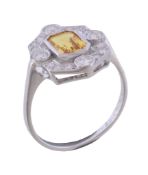 A yellow sapphire and diamond ring, the central rectangular cut yellow sapphire within a surround