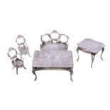 A collection of silver doll's house or toy furniture, variously embossed, comprising: a table by