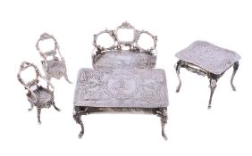 A collection of silver doll's house or toy furniture, variously embossed, comprising: a table by