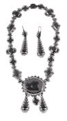 A 19th century Berlin ironwork and cut steel necklace and earrings , circa 1840, the principal oval