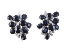 A pair of sapphire and diamond cluster earrings, set with oval cut sapphires and eight cut